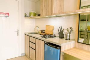 a kitchen with a sink and a stove top oven at Simple and Cozy Living Studio Room at Poris 88 Apartment By Travelio in Tangerang