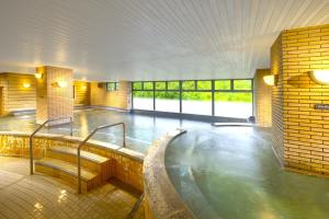 a large room with a hot tub in a building at Hotel Green Plaza Hakuba in Otari +67 photos