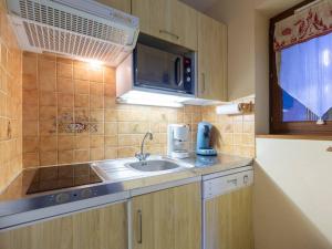 una piccola cucina con lavello e microonde di Chalet cosy 6 pers Peyragudes, navette ski, animaux ok, cheminée, barbecue - FR-1-695-62 a Gouaux-de-Larboust Altre 7 foto