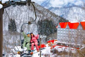 小谷村にある奥白馬温泉　ホテルグリーンプラザ白馬の雪の中のスキーリフトに乗って2名