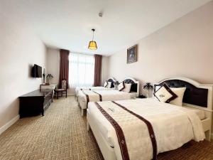 Postel nebo postele na pokoji v ubytování Ngoc Phat Dalat Hotel