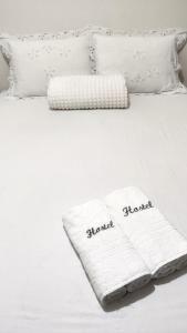 a white blanket on a white bed with pillows at Apt perto do shopping in Petrolina