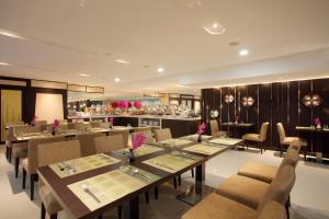 a restaurant with tables and chairs and a kitchen at Chiva Bangkok Hotel - SHA Plus in Bangkok