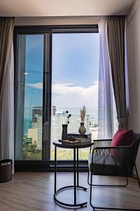 a living room with a table and a large window at Luxury Condo Edge Central Pattaya in Pattaya Central