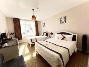 Postel nebo postele na pokoji v ubytování Ngoc Phat Dalat Hotel
