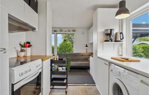a kitchen with white appliances and a living room at Stunning Home In Bogense With Wifi in Bogense