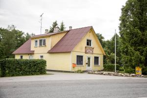 a yellow building with a red roof at Puuna Öömaja B&B in Vihterpalu