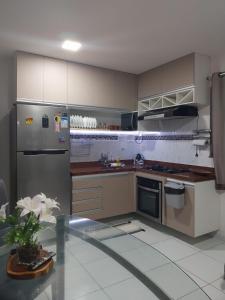 a kitchen with stainless steel appliances and a glass table at FlatsJasmim, Apartamento completo Jacumã-Conde in Conde +1 photo