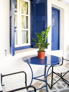 a blue table and chairs on a porch with a plant at Drakos Twins in Mylopotas