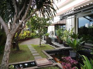 a garden with a pond in the middle of a building at Cozy Furnished 3BR at Grand Setiabudi Apartment By Travelio in Bandung