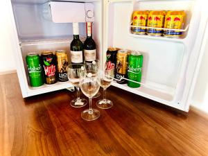 an open refrigerator with two wine glasses and drinks at The Blue Sapphire Of Wilpattu in Wilpattu +85 photos