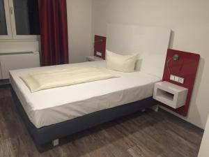 Bett in einem kleinen Zimmer mit einem roten und weißen Bettrahmen in der Unterkunft Hotel Arts in Sankt Leon-Rot