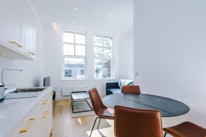 a kitchen and living room with a table and chairs at Stylish 1-Bedroom Getaway in Sale in Sale