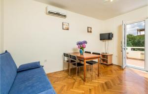 a living room with a table and a blue couch at 2 Bedroom Awesome Apartment In Stara Novalja in Stara Novalja