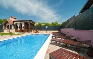 a swimming pool with benches next to a house at Beautiful Home In Hrvace With Wifi in Hrvace