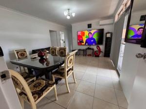 a dining room with a table and chairs and a tv at Alison's central apartment in Cabramatta