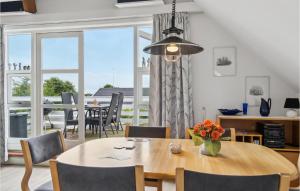 a dining room with a table and chairs and a large window at Holiday Apartment Skagen 01 in Skagen