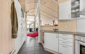a kitchen with white cabinets and a dining room at Holiday Home Frankelund Tranekær Ii in Hou