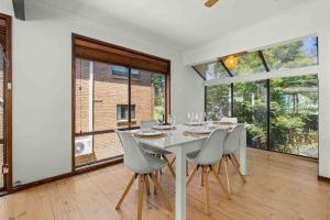 a dining room with a white table and chairs at Karalee by Experience Jervis Bay in Vincentia