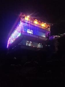 una casa decorada con luces de Navidad por la noche en Jibhi mountain view 1, en Jibhi 3 fotos más