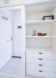 a white walk in closet with white shelves at Rare New Marina Hotspot With Fast Free WIFI, Balcony & Pool - Western Standards - Sheraton Plaza 414 in Hurghada