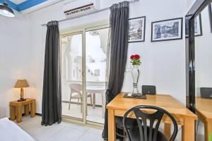 a dining room with a table and a desk with a vase of flowers at Rare New Marina Hotspot With Fast Free WIFI, Balcony & Pool - Western Standards - Sheraton Plaza 414 in Hurghada