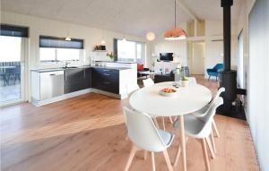 a kitchen and dining room with a white table and chairs at Three-Bedroom Holiday Home In Hvide Sande in Bjerregård