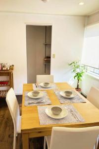 a dining room table with white chairs and a wooden table at Ivy Cottage 3F - Vacation STAY 42187v in Kumamoto