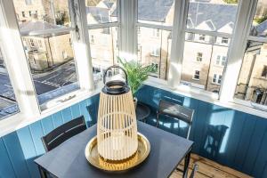 a table with a bird cage on it in a room with windows at The Lookout in Alnwick