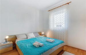 a bedroom with a bed with two towels on it at 2 Bedroom Nice Apartment In Mali Losinj in Mali Lošinj