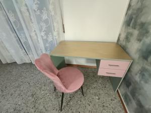 Ein rosa Stuhl steht neben einem Schreibtisch mit einer rosa Schublade. in der Unterkunft Attico Stadio in Pescara + 44 Fotos