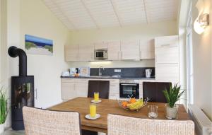 a kitchen with a table with a bowl of fruit on it at Cozy Home In Dagebüll With Kitchen in Dagebüll