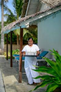 a man standing under a table with a cake at Bedrock Beach Villas in Kalpitiya