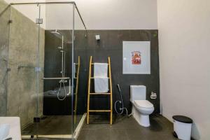 a bathroom with a toilet and a glass shower at Bedrock Beach Villas in Kalpitiya