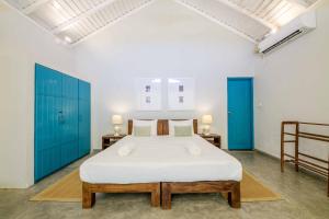 a bedroom with a large bed with blue cabinets at Bedrock Beach Villas in Kalpitiya