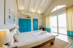 a bedroom with a large bed with blue cabinets at Bedrock Beach Villas in Kalpitiya