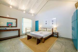 a bedroom with a bed and a table and a mirror at Bedrock Beach Villas in Kalpitiya