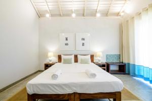 a bedroom with a large white bed in a room at Bedrock Beach Villas in Kalpitiya