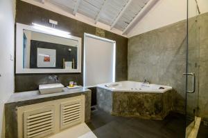a bathroom with a sink and a glass shower at Bedrock Beach Villas in Kalpitiya