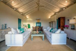 a living room with two white couches and a coffee table at Bedrock Beach Villas in Kalpitiya