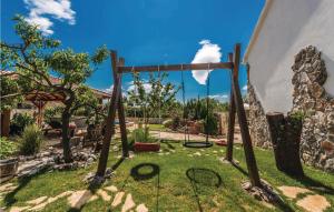 - un jardin avec une balançoire dans la pelouse dans l'établissement Two-Bedroom Holiday Home In Zemunic Gornji, à Vlašnović 41 autres photos