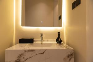 a bathroom sink with a mirror and a vase on it at شقه 7فاخره ثلاث غرف نوم وجلسه خارجيه in Riyadh +48 photos
