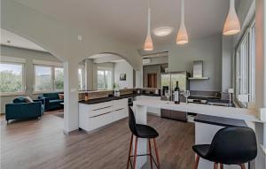 Una cocina abierta con dos taburetes de bar y una sala de estar. en Nice Home In Sreser With Jacuzzi, en Sreser