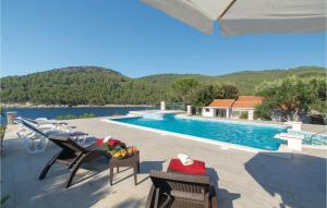 a patio with chairs and a swimming pool at Holiday Home Poplat 19 in Vela Luka +27 photos