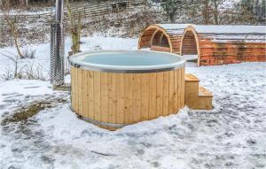 una vasca idromassaggio nella neve accanto a un wicket di Amazing Home In Ebeltoft With Sauna a Ebeltoft Altre 42 foto