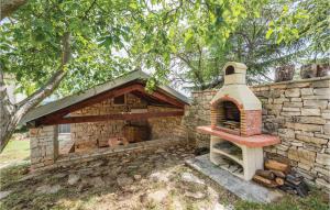 an outdoor brick oven sitting next to a tree at Holiday Home Markovac 11 in Markovac