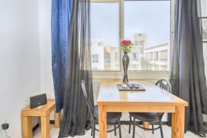 a dining room table with a vase of flowers on it at Rare New Marina Hotspot With Pool & Fast Free WIFI - Western Standards - Sheraton Plaza 415 in Hurghada