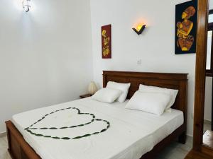 a bedroom with a large bed with white sheets at Damithshouse in Bentota