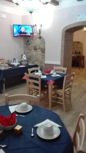 a dining room with blue tables and chairs and a tv at Agriturismo San Michele in Paternopoli