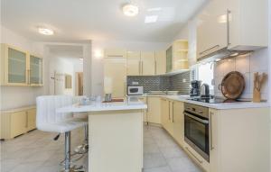 duża kuchnia z białymi szafkami i blatem w obiekcie Four-Bedroom Holiday Home In Perci w mieście Perkovići